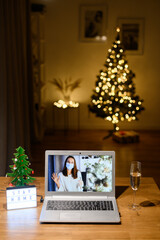 Online meeting with a girl in medical mask. Webcam screen young woman wearing protective mask. Virtual celebration Christmas with friend via video call. Stay home concept