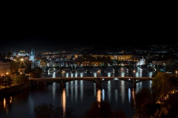 Foto op Plexiglas .view of illuminated bridges on the Vltava river in the center of Prague at night © svetjekolem
