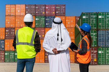 Middle Eastern Businessman and engineers working outside on a large commercial dock during