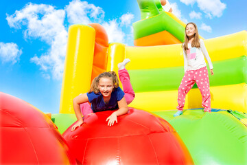 Happy little girls having lots of fun while jumping from ball to ball on an inflate castle.