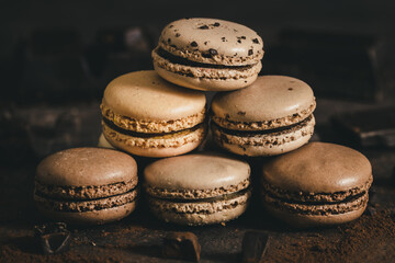 Stacked brown macarons on dark background