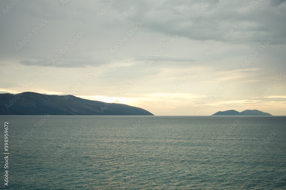 Wall mural sunset in the sea clouds horizon coast albania