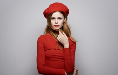 Pretty woman in red dress cosmetics elegant style emotions red hat gray background