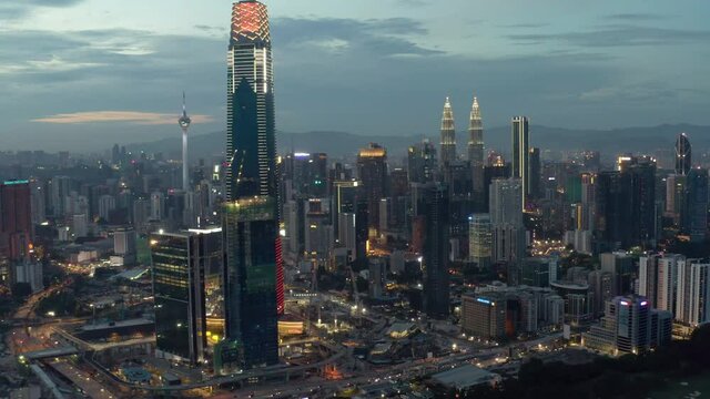 Establishing aerial cinematic drone b-roll shot of sunset at Kuala Lumpur city skyline. 