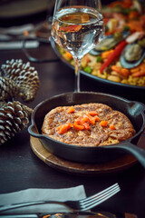 Spanish dinner table with assortment of dishes. paella, octopus, whole fish, sangría and wine. Dressed for christmas