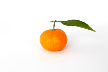 Ripe tangerine with leaves close-up on white background.