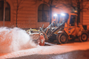 Process of snow removal on the city streets and roads with municipal vehicle, bulldozer, snowblower...