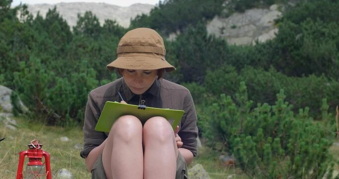 Young woman artist paint landscape with mountains outdoors