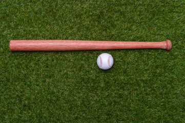 tBaseball bat and ball on green grass field.  Sport theme background with copy space for text and advertisment