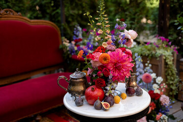 wedding decoration on the white table with fruits, flowers and antiques