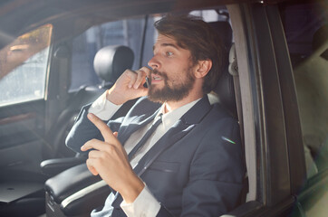 business man in a suit talking on the phone in a car finance model