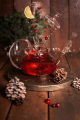 Glass teapot with tea and berries. Hot berry tea. Drink