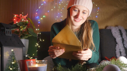 Happy young woman reading Christmas greeting card
