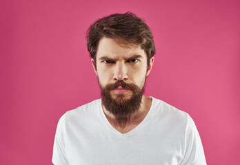 Man with bushy beard on a pink background white t-shirt cropped view