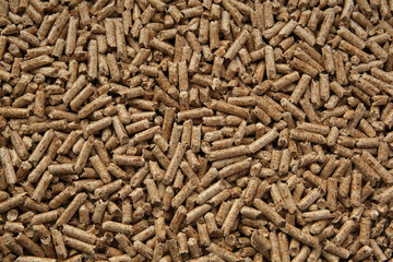 Wood pellets texture. Pellets made from compressed wood and used as natural cat litter. Eco-friendly and biodegradable material. High contrast, sharp, flat lay image.