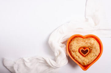 Fruitcake baked in the shape of a heart on a white background with space for text.