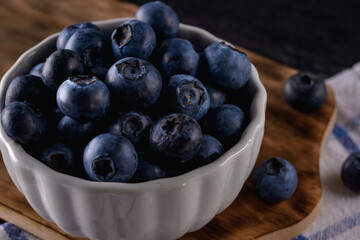 Fresh blueberry in white bowl on black backround