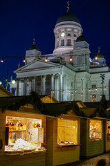Illuminated Christmas market stalls beneath the Helsinki Cathedral