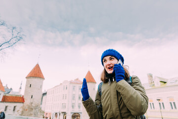Tallinn, Estonia. Young Caucasian Woman Backpacker Tourist Enjoying Life, Smiling And Calling On...