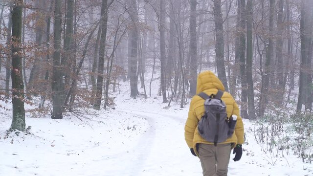 Image of man with yellow jacket walking at trail during the winter, Zagreb.