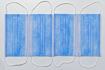 template of four disposable face masks on white painted background