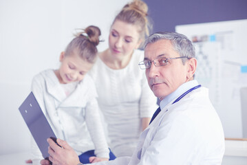 Fototapeta premium Little girl with her mother at a doctor on consultation