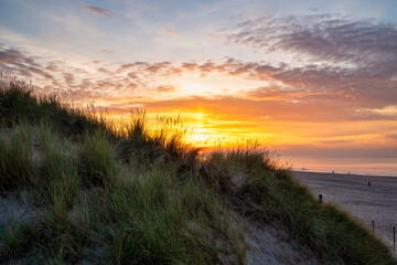 Beautiful golden colors of the sun setting behind a sand dune, during sunset