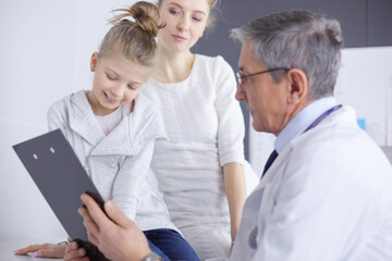 Fototapeta premium Little girl with her mother at a doctor on consultation