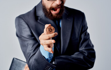 Business man with a coin in his hands and a puzzled look gesticulate with his hands Bitcoin...