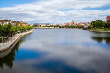 Urban landscape of the city of Mirandela in the north of Portugal. Panoramic view of the banks of the river Tua with the traditional Roman bridge and the historic center with its church tower.