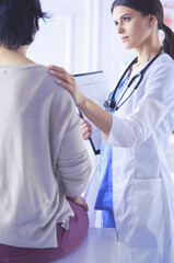 Medical consultation. Female doctor holding a patient by her shoulder, soothing her fear