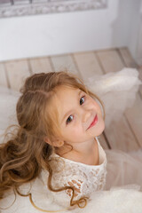 Christmas shooting of a cute little girl in the studio with wings