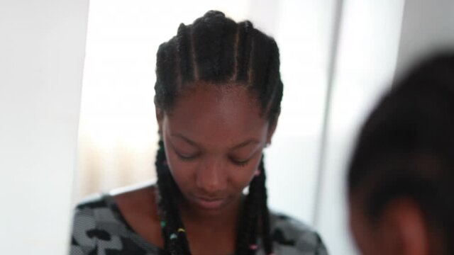 African black adolescent teenage girl standing in front of mirror
