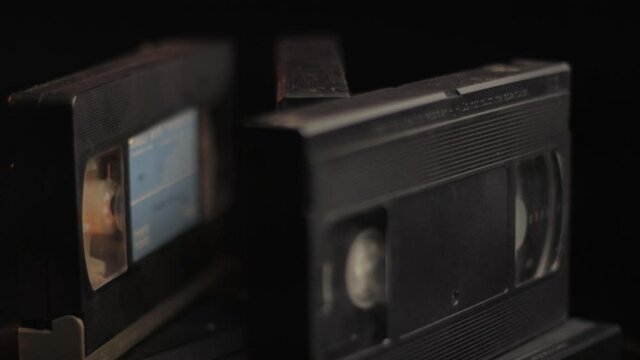 Close Up of VHS Video Tapes, Videocassettes Spinning on Black Backround. Vintage Video Media From 1980s and 1990s, Full Frame