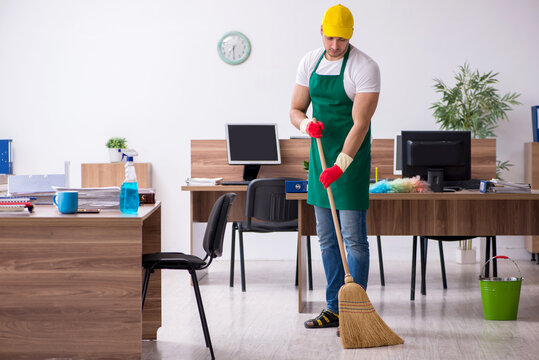 Young male contractor cleaning the office