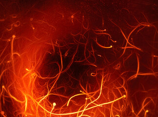 Abstract photograph of burning red and orange filaments on a black background