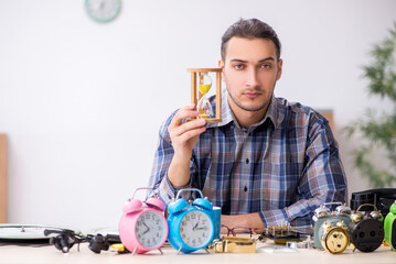 Young male watchmaker working in the workshop