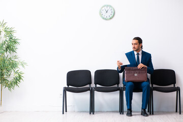 Young businessman waiting for an interview at hall