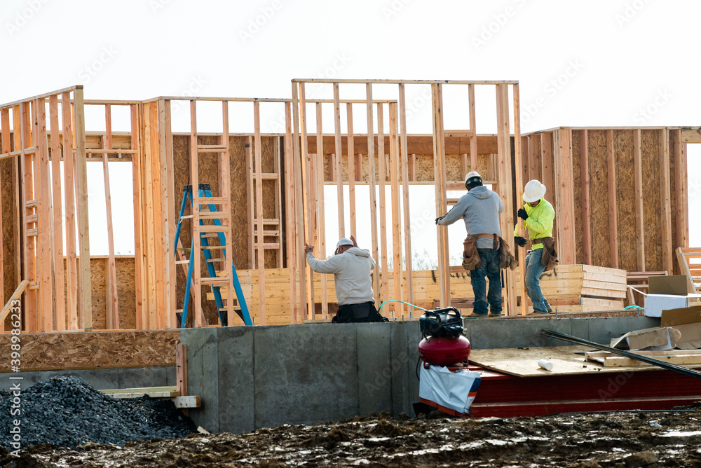 Wall mural workers are installing the frame of a plywood house