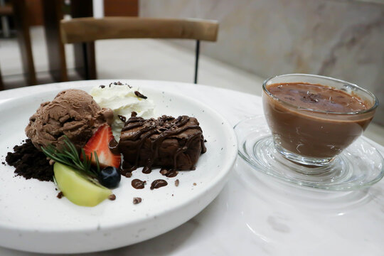 brownie , chocolate ice cream with whipping cream and hot chocolate