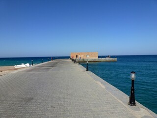 Deserted pier with technical construction and a view of the endless horizon