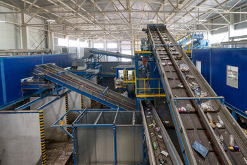 Waste sorting plant conveyors filled with various household waste.