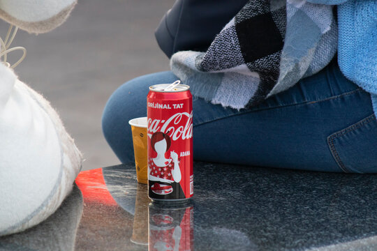 The coca cola can of cola that people drink while eating. Made of red aluminum. It stands on black marble.