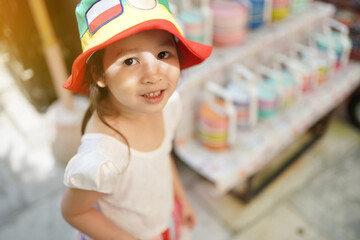 Cute little Asian girl wearing green and yellow headgear, kid concept happy to wear hat.