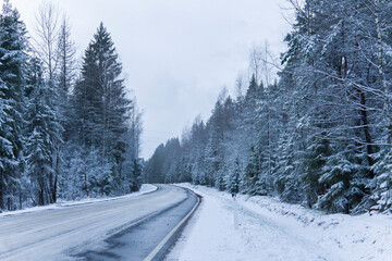 Obraz premium Snowy road in winter forest. Beautiful frosty white landscape.