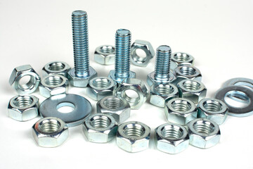 group of bolts and nuts made of metal on a white background