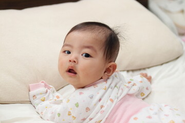 寝室のベッドで寝転がる赤ちゃん