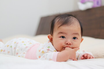 寝室のベッドで寝転がる赤ちゃん