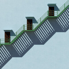 Green iron stairs beside a tall building. Light and Shadow Concept.