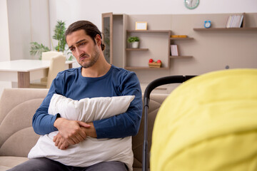 Young male contractor looking after baby at home